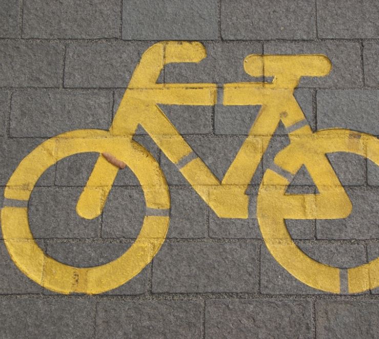 yellow chalk outline of a bicycle against a brick background
