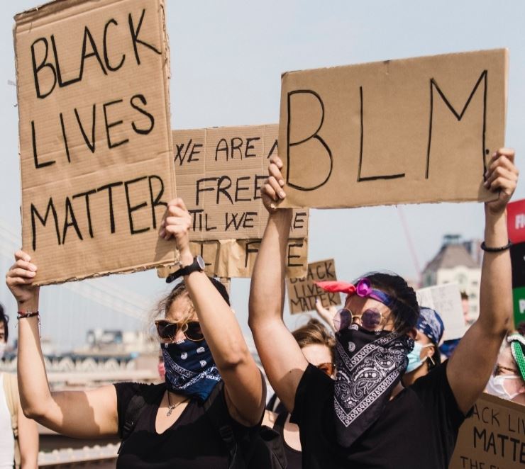 Protesters holding signs that say Black Lives Matter and BLM