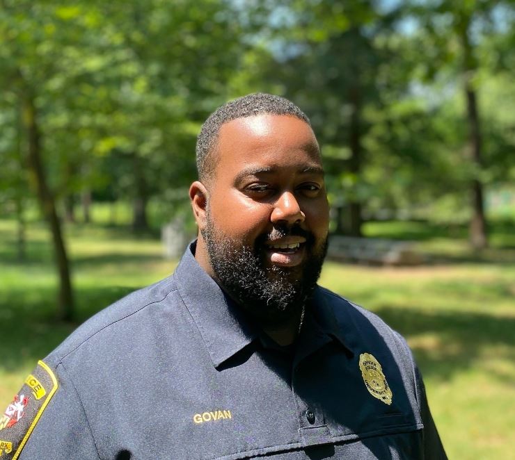 Pfc Officer Ronald Govan Jr standing in the Town Park with trees and greenery behind him 