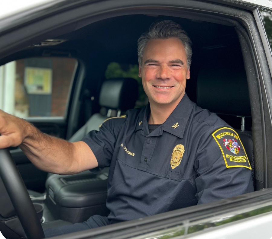 D Coleman sitting in driver's seat, smiling out window at camera