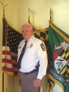 Captaom Standing in Front of Flags